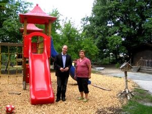 Carsten Göller gemeinsam mit Leiterin Kemp vor einem von Eltern gestifteten Spielgeräte im Kindergarten in Weyer.